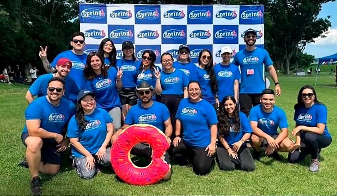 Equipe uniformizada Spring School pousando para a foto no gramado.