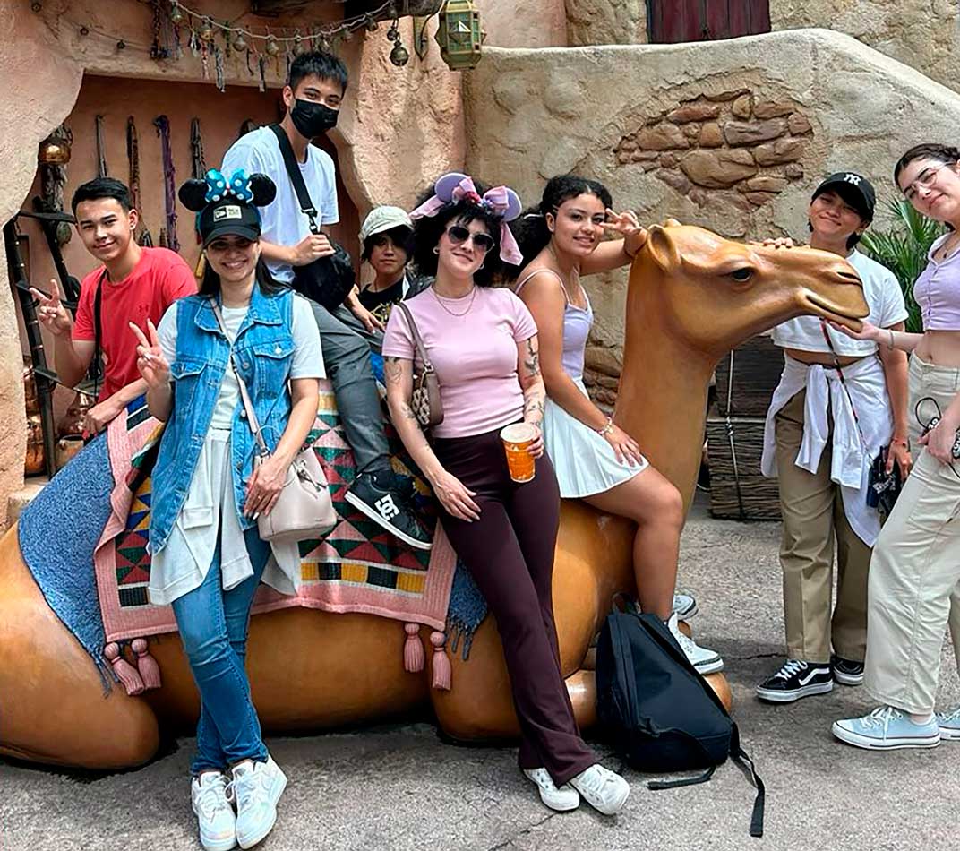 Alunos da Spring School apoiados em um boneco de Camelo no tamanho real do parque da Disney de Tóquio.