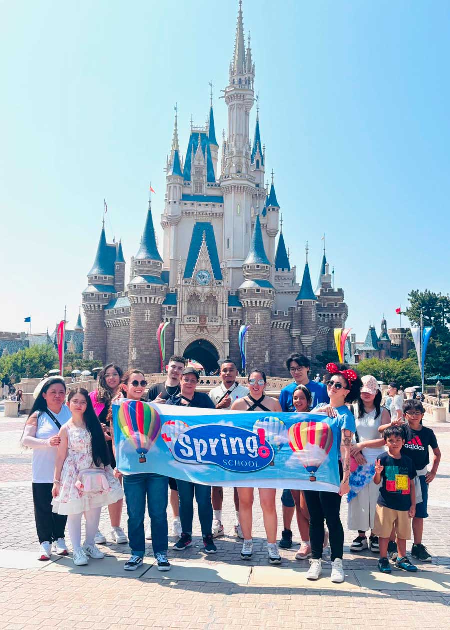 Alunos da Spring School pousando para a foto na Tokyo Disneyland à frente do castelo.